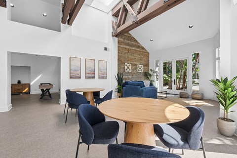 A living room with a wooden table surrounded by chairs.
