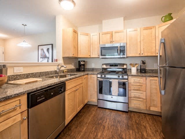 a kitchen with wooden cabinets and stainless steel appliances