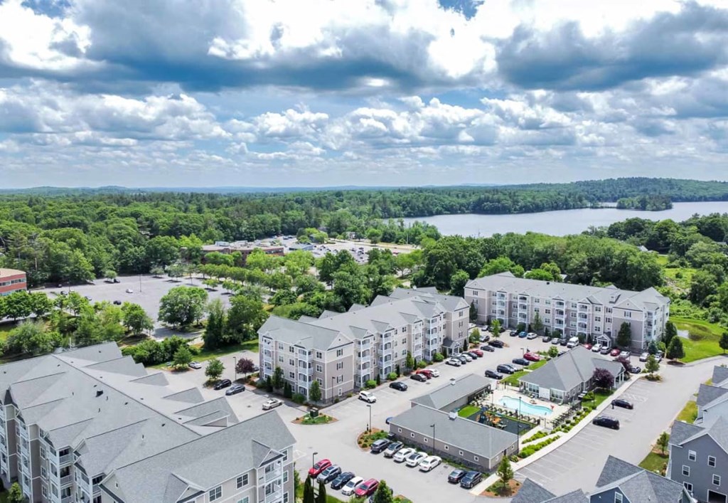 an aerial view of an apartment complex with a lake in the background