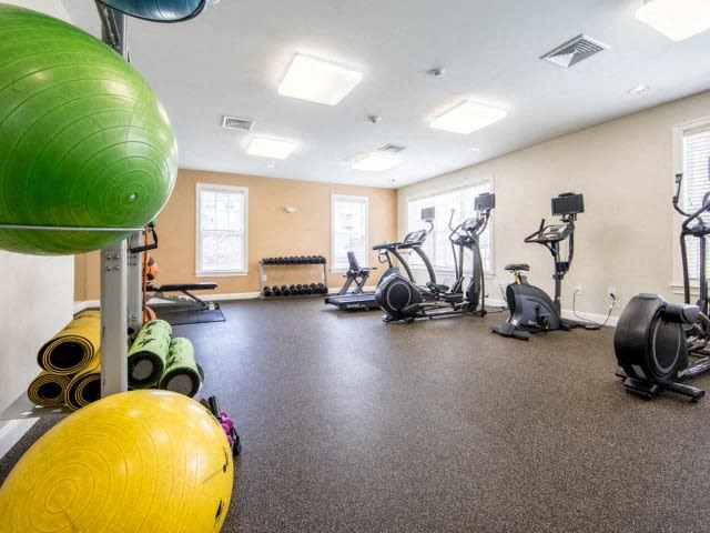 a gym with exercise equipment and weights on the floor