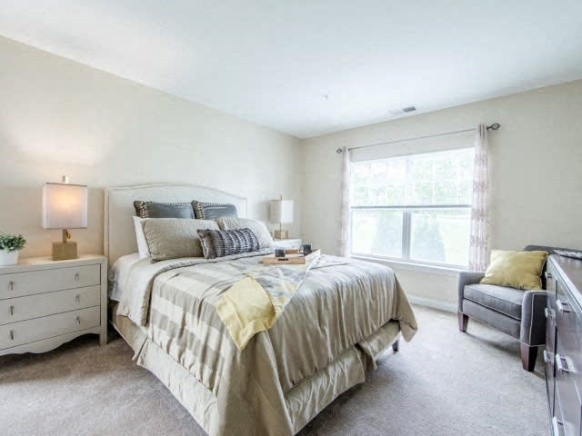 a bedroom with a bed sitting next to a window