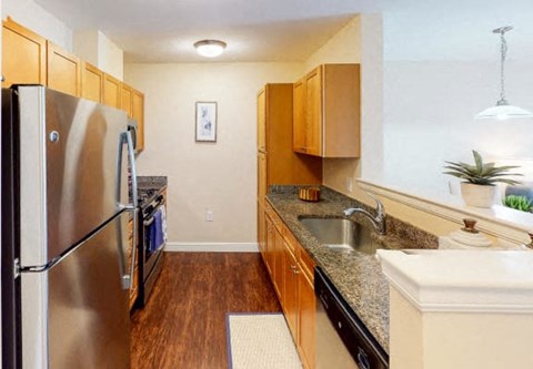 a kitchen with a stainless steel refrigerator and a sink