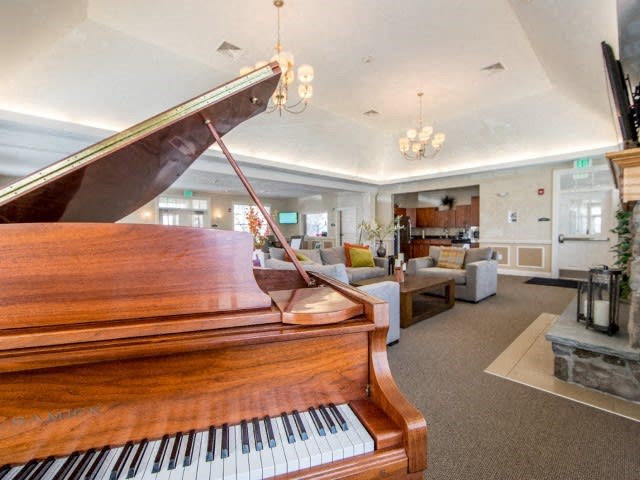 a piano sitting in a living room next to a fire place