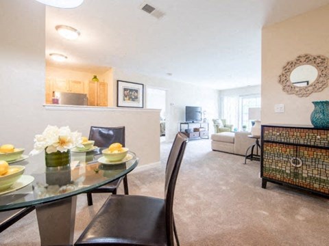 a living room and dining room with a table and chairs