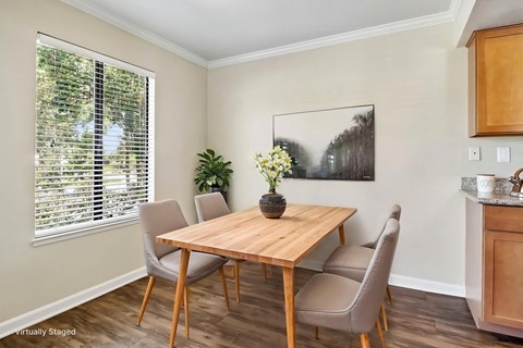 A dining room with a wooden table and chairs.