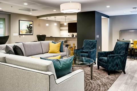 A modern living room with a grey couch and blue chairs.