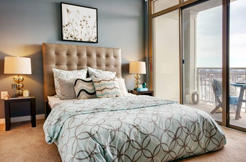 A bedroom with a large bed and a view of the balcony.