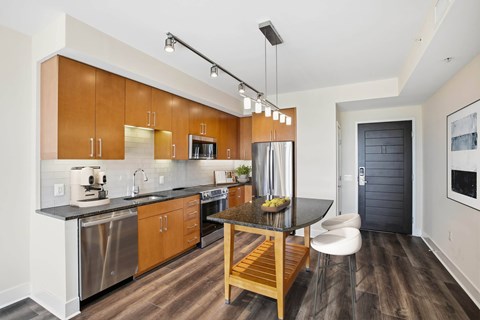 A modern kitchen with wooden cabinets and a black countertop.