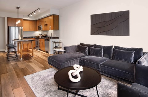 A modern living room with a black couch and a coffee table.