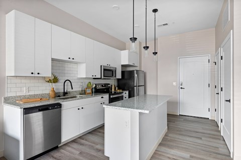 A modern kitchen with white cabinets and a central island.