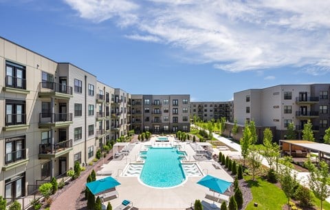 A large swimming pool surrounded by apartment buildings.