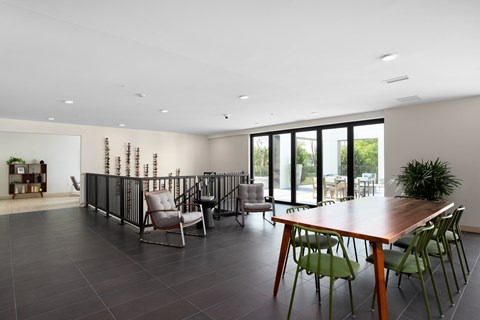 A modern dining room with a long table and chairs.