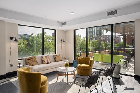A sunny day in a modern living room with a white sofa and yellow chairs.