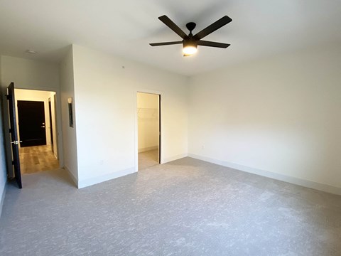 an empty living room with a ceiling fan
