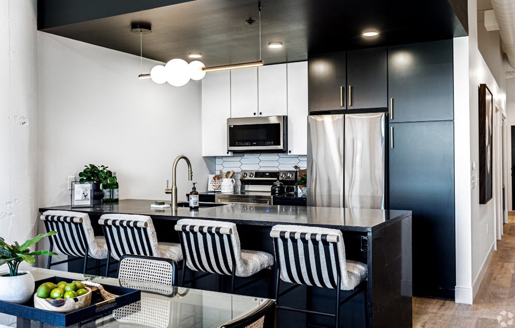 a black and white kitchen with a counter and chairs