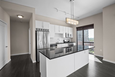 A modern kitchen with white cabinets and a black countertop.