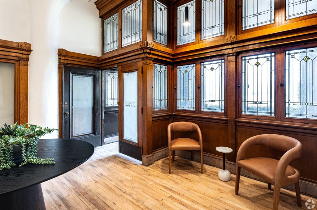 the lobby of a building with chairs and a table