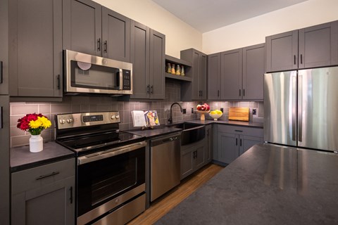 a kitchen with stainless steel appliances and gray cabinets