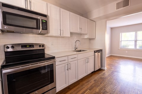 a kitchen with white cabinets and stainless steel appliances a kitchen with white cabinets and stainless steel appliances