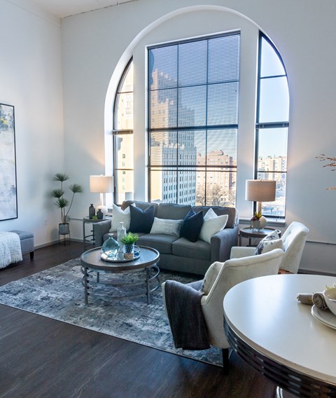 a living room with a large arched window and a couch