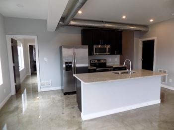A modern kitchen with a large island and stainless steel appliances.