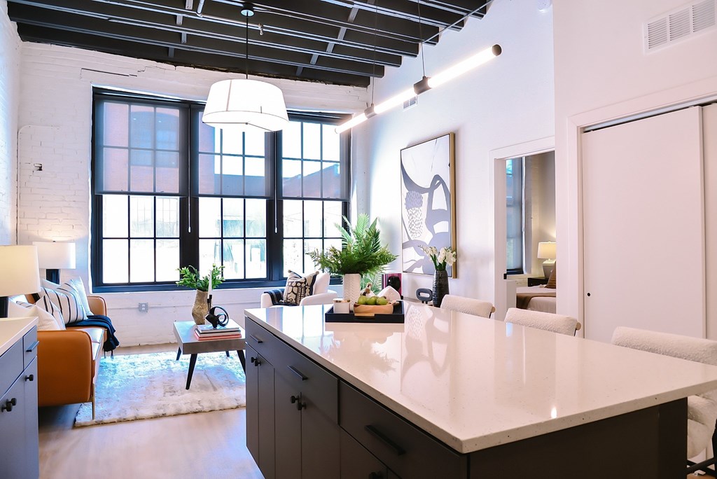 A kitchen with a large island and a dining table with chairs.