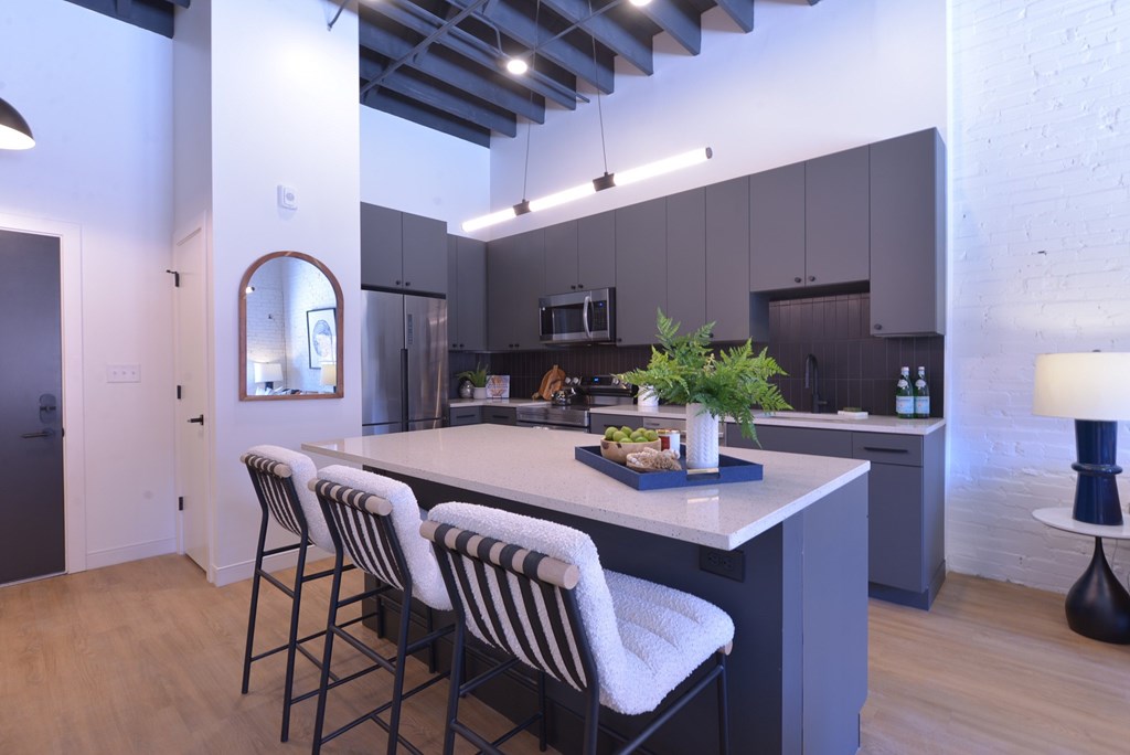 A kitchen with a bar area and striped chairs.