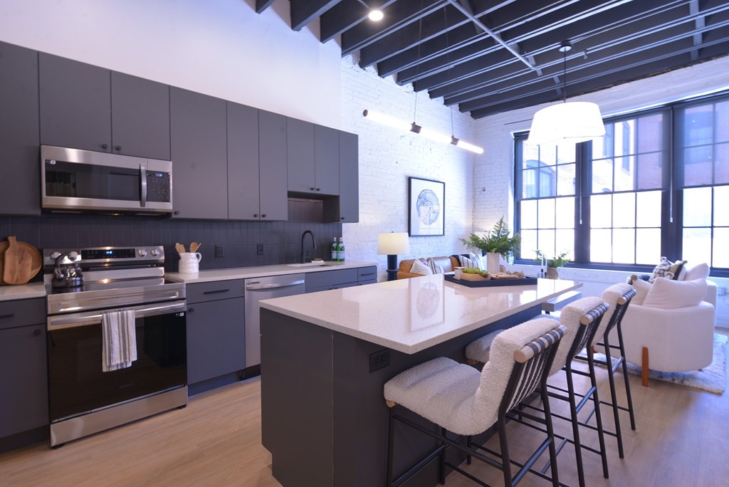 A modern kitchen with a large island and bar stools.