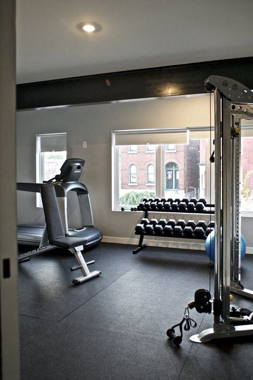 A gym room with a row of dumbbells and a bench press.