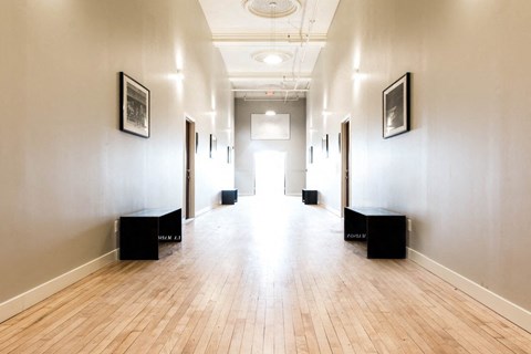 A long hallway with wooden floors and white walls.