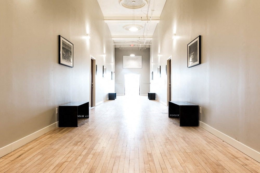A long hallway with wooden floors and white walls.