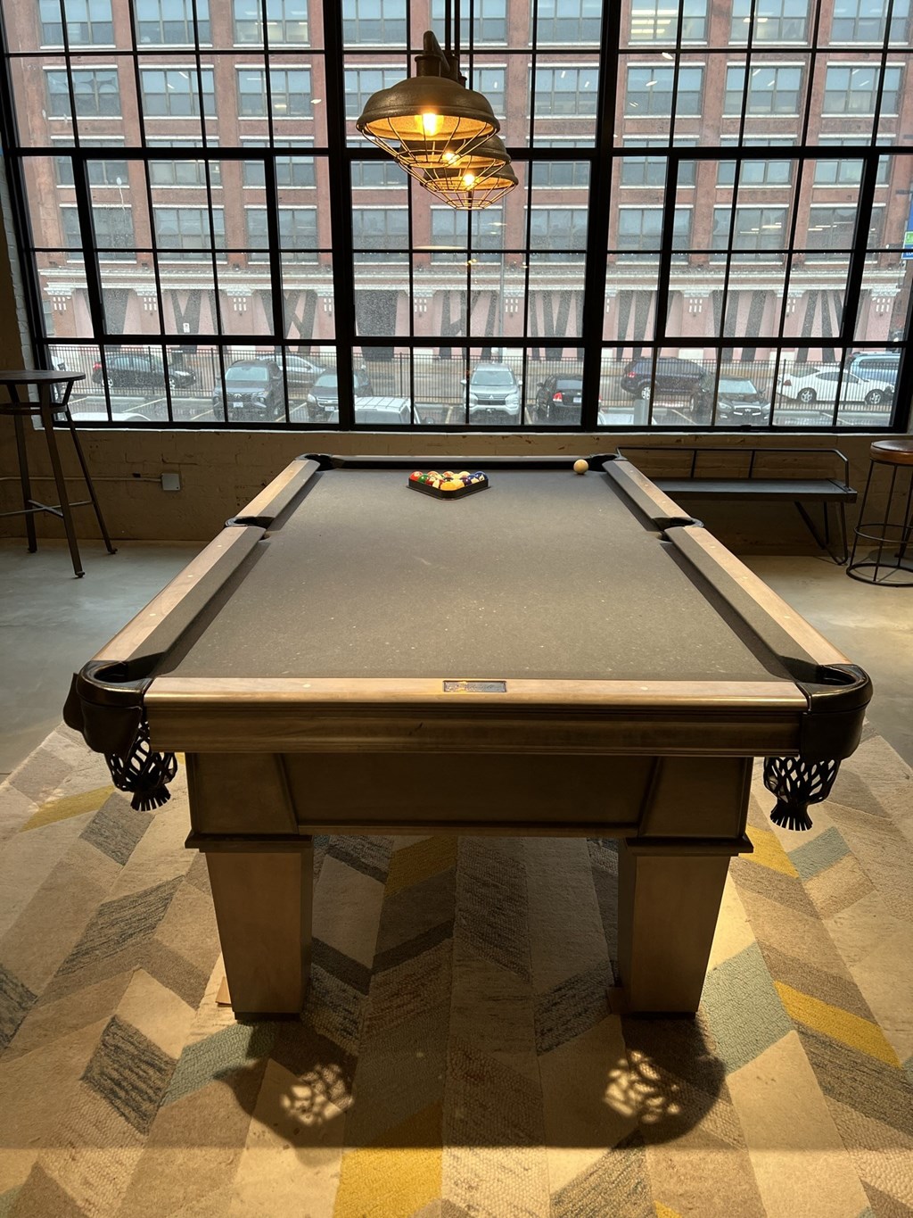 a pool table sits in front of a large window in a room with a checkered