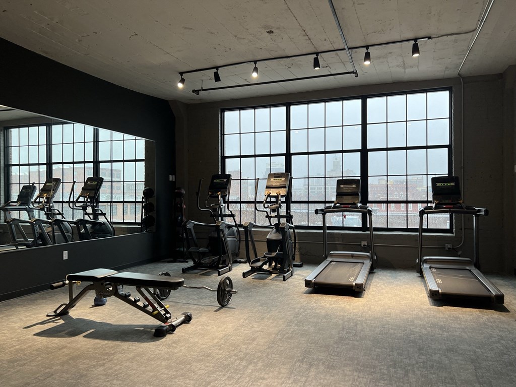 a fitness room with treadmills and other exercise equipment