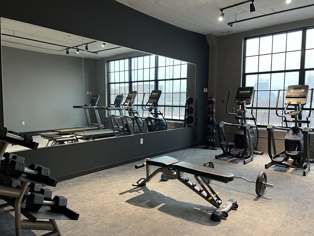 a large mirror in a gym with weights and other exercise equipment