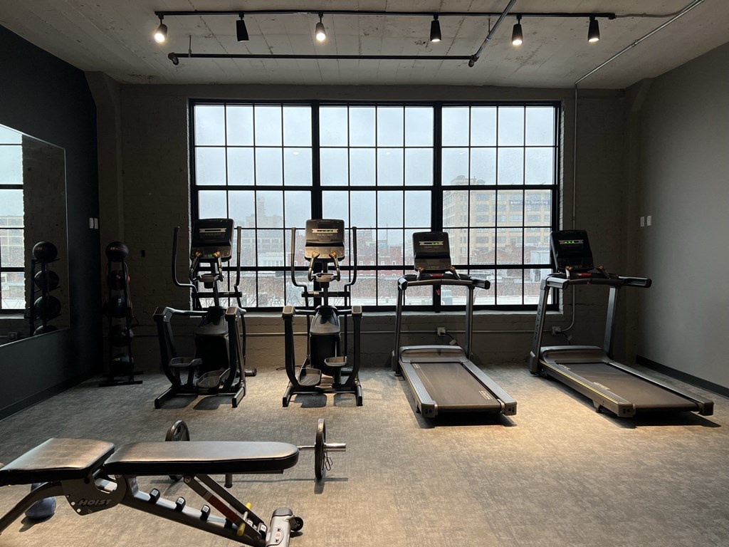 a fitness room with treadmills and other exercise equipment