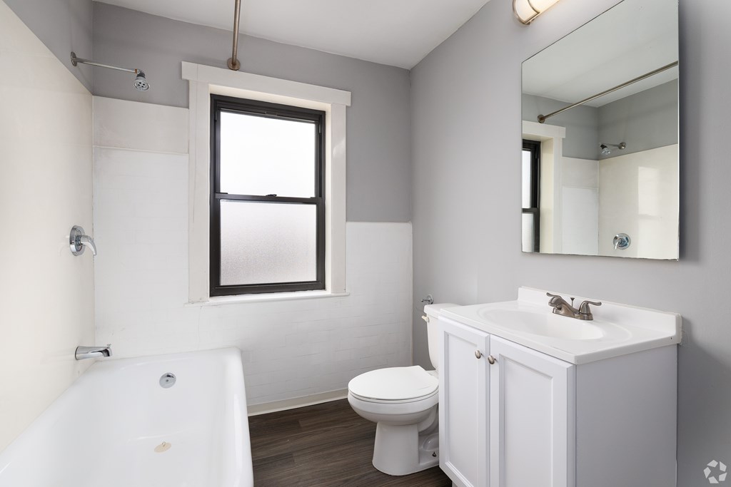 A white bathroom with a toilet, sink, and bathtub.