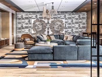 A modern living room with a grey sofa set and a wooden floor.
