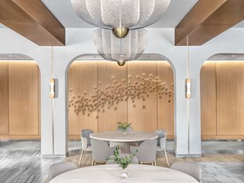 A modern dining room with a round table and grey chairs.