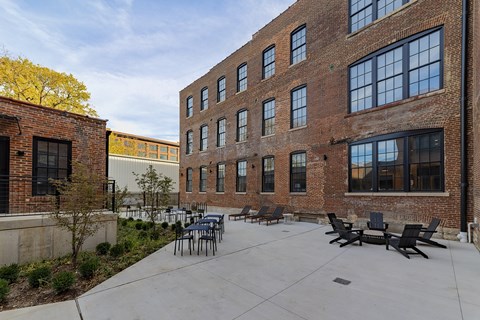 A courtyard with a table and chairs surrounded by brick buildings.