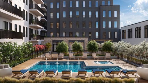 A large swimming pool surrounded by lounge chairs and buildings.