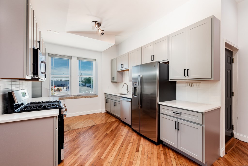A kitchen with wooden floors and stainless steel appliances.