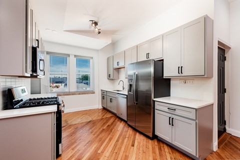A kitchen with wooden floors and stainless steel appliances.