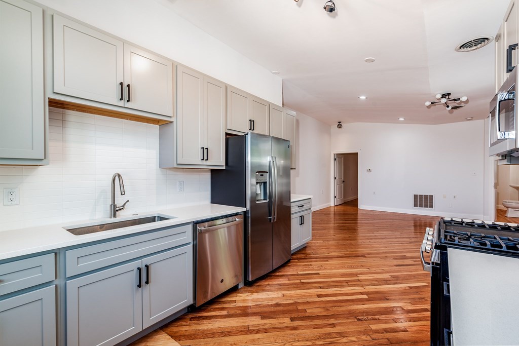 A kitchen with wooden floors and stainless steel appliances.