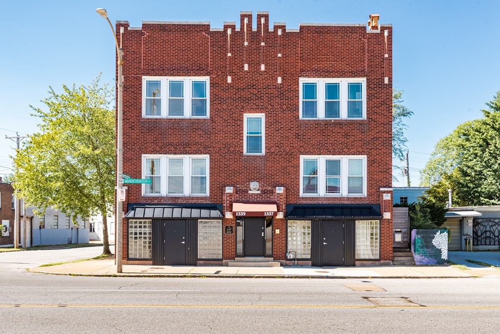A red brick building with a black awning on the front.