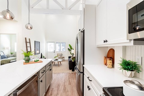 A modern kitchen with white cabinets and stainless steel appliances.
