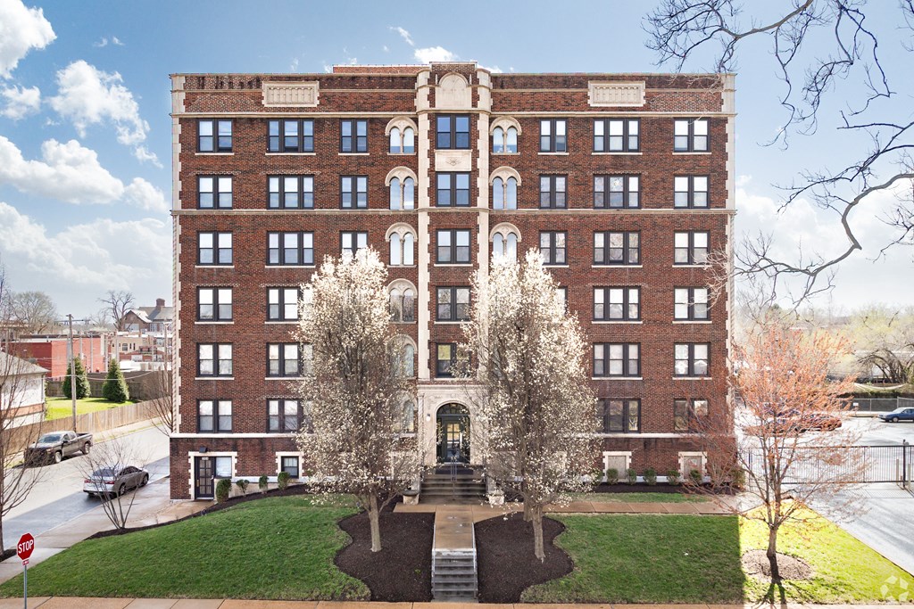 A large red brick building with a green lawn in front.