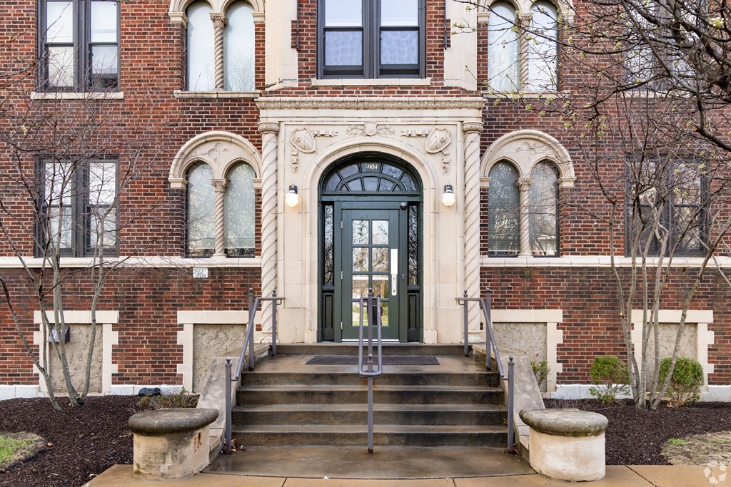A large, ornate front door is flanked by two stone pillars.