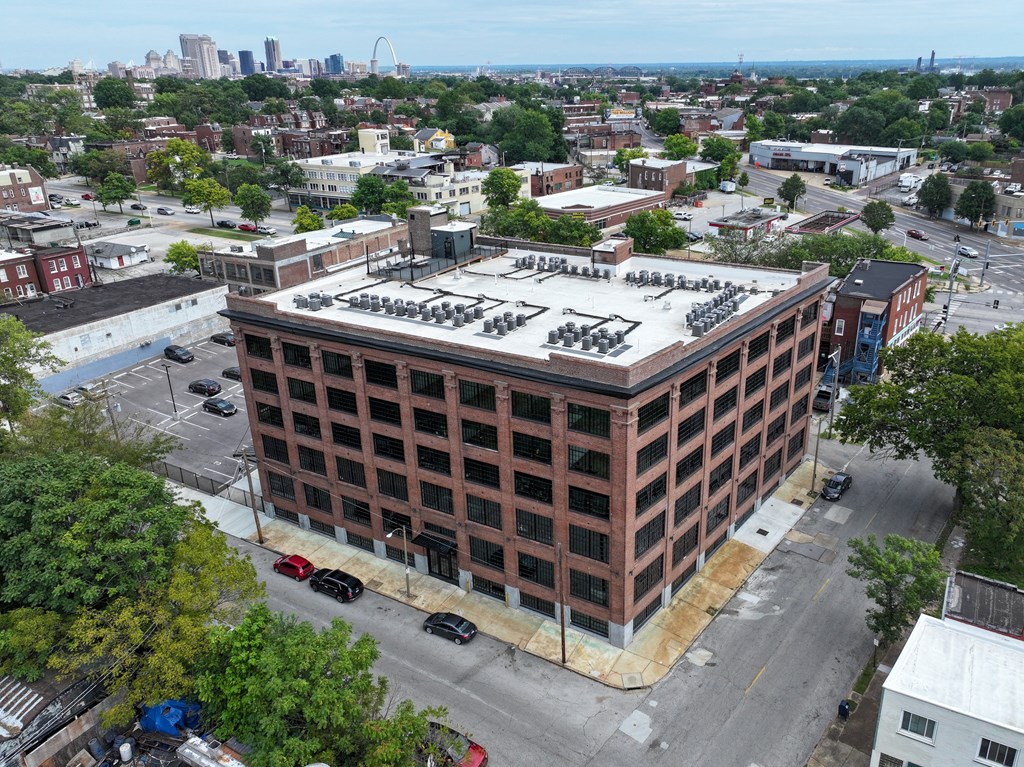 an aerial view of a brick building with a white roof