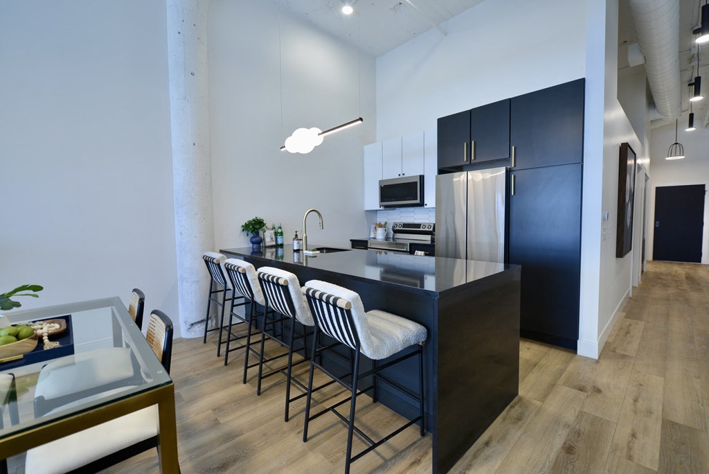 a kitchen with a long island with bar stools and a black