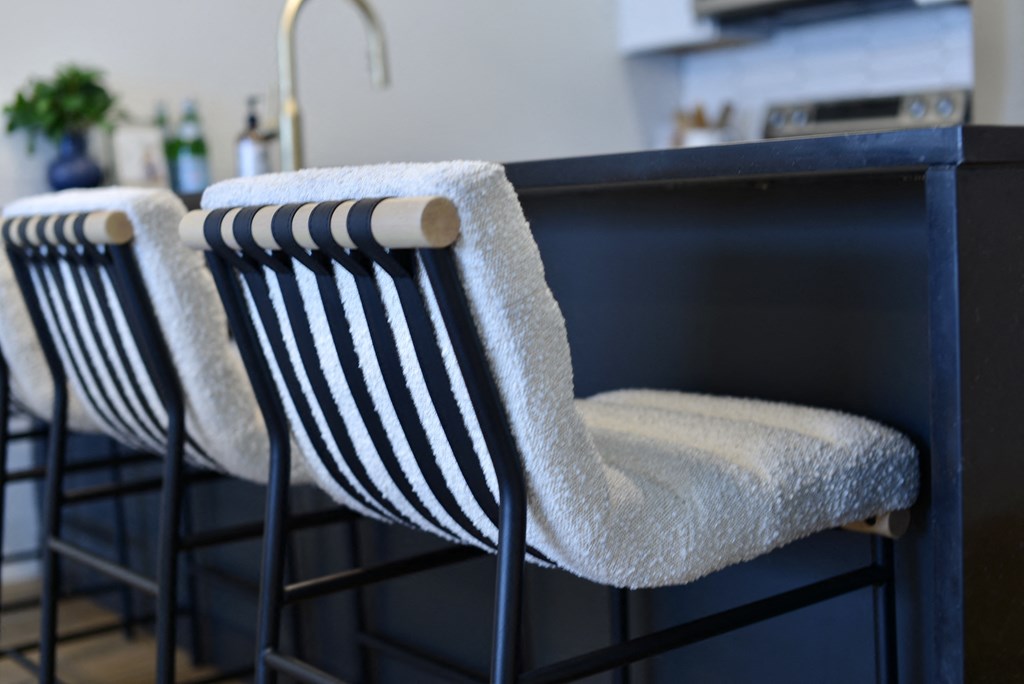 three black and white striped chairs with a white towel on the back